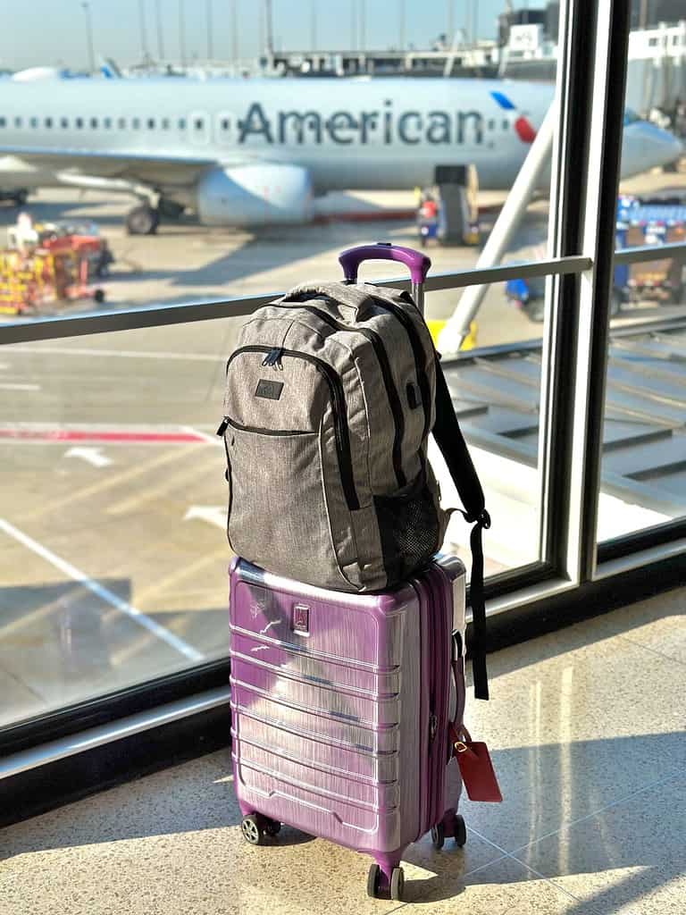 Carry on hard side luggage by Travel Pro with a backpack ready to take off at the airport gate