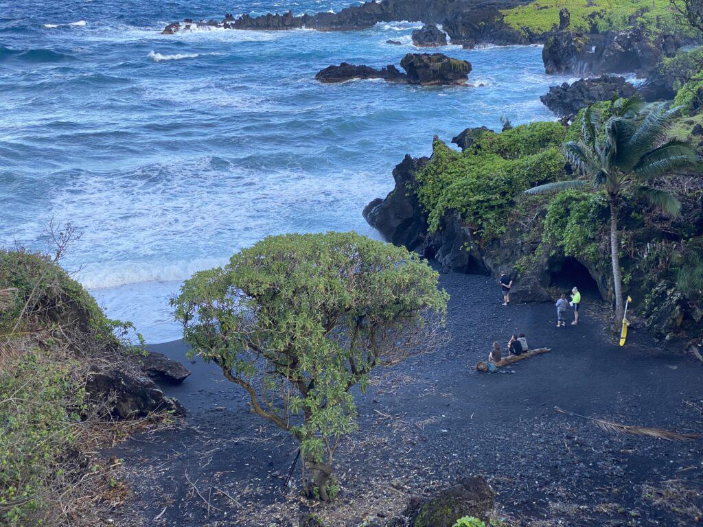 Overlook of the famous Honokalani Black Sand Beach at Wai'anapanapa State Park on the Road to Hana. The black sand is created from the lava rock ground up by the ocean. 