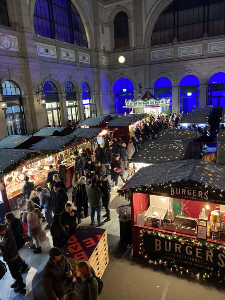 The Christkindlimarkt at the Zurich Central Station with lots of chalets selling food and handcrafted items.