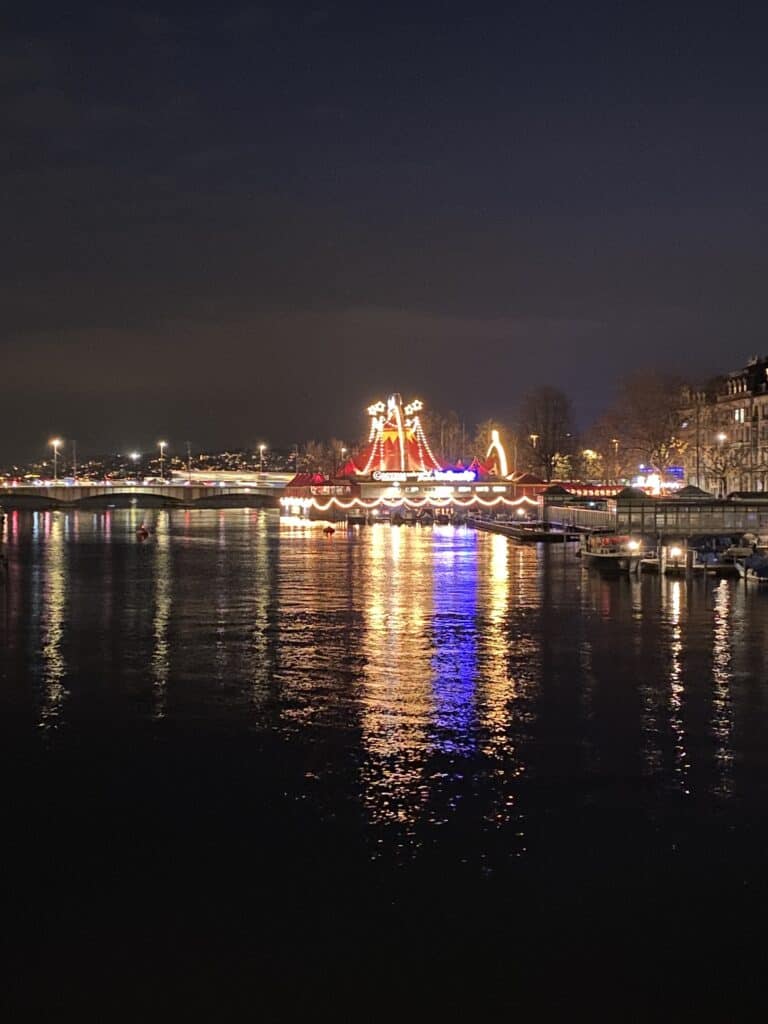 The Circus Conelli lights glowing across Lake Zurich. 