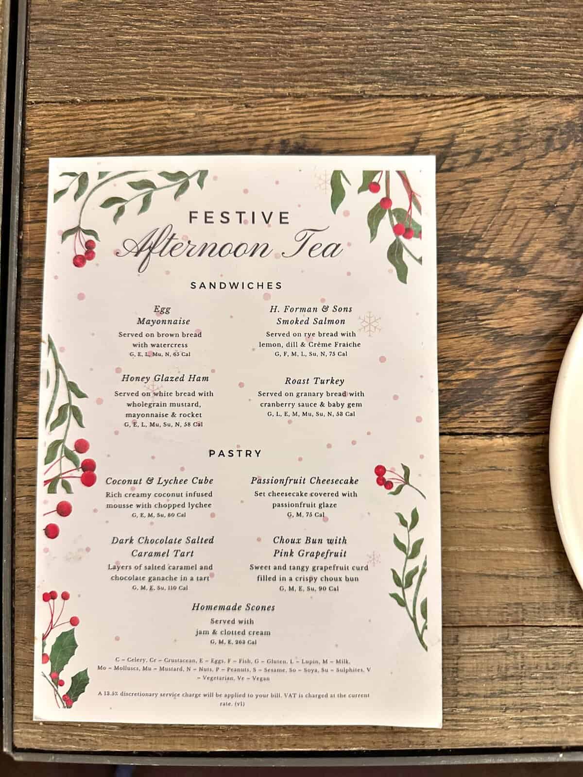 A festive afternoon tea menu at Andaz London Liverpool Street, detailing a selection of sandwiches, pastries, and scones with ingredient lists.