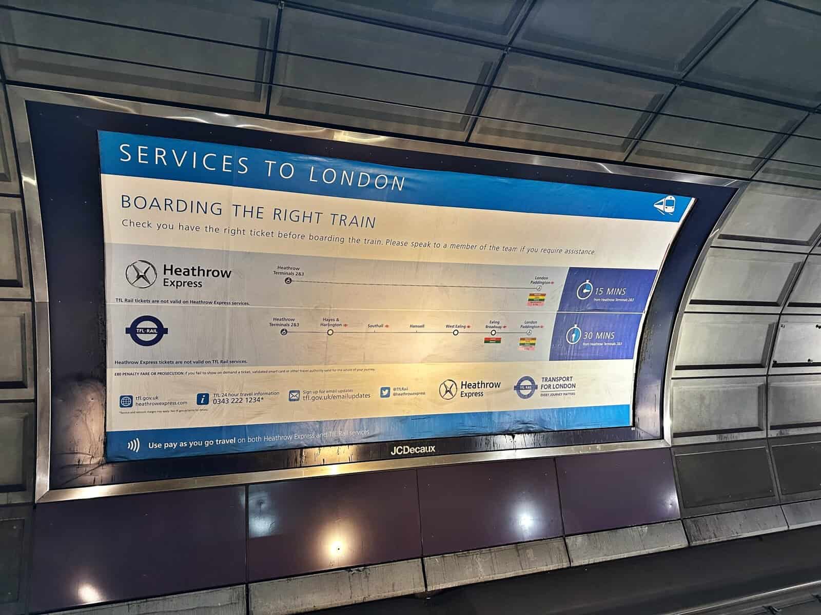 An informational sign at a train station comparing travel times and routes to London, including services relevant for guests heading toward the Andaz London Liverpool Street.