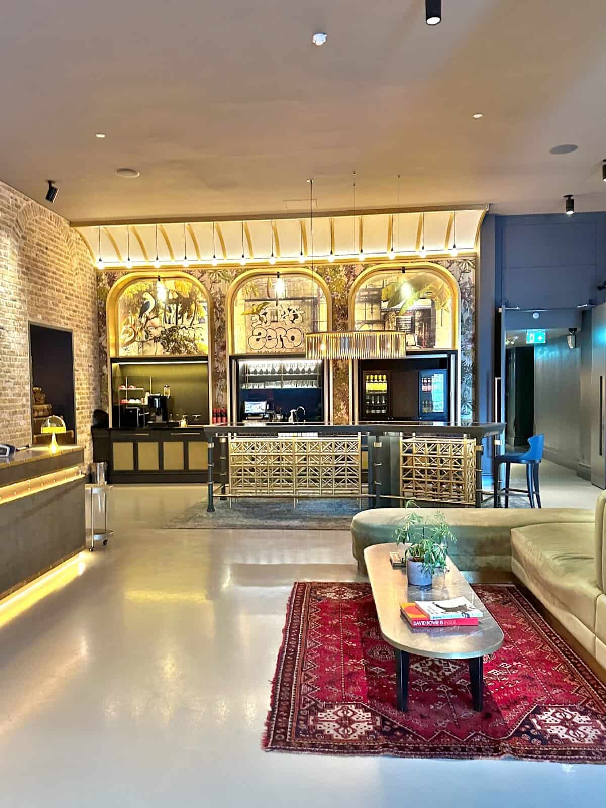 Modern bar interior with warm lighting and a patterned rug.