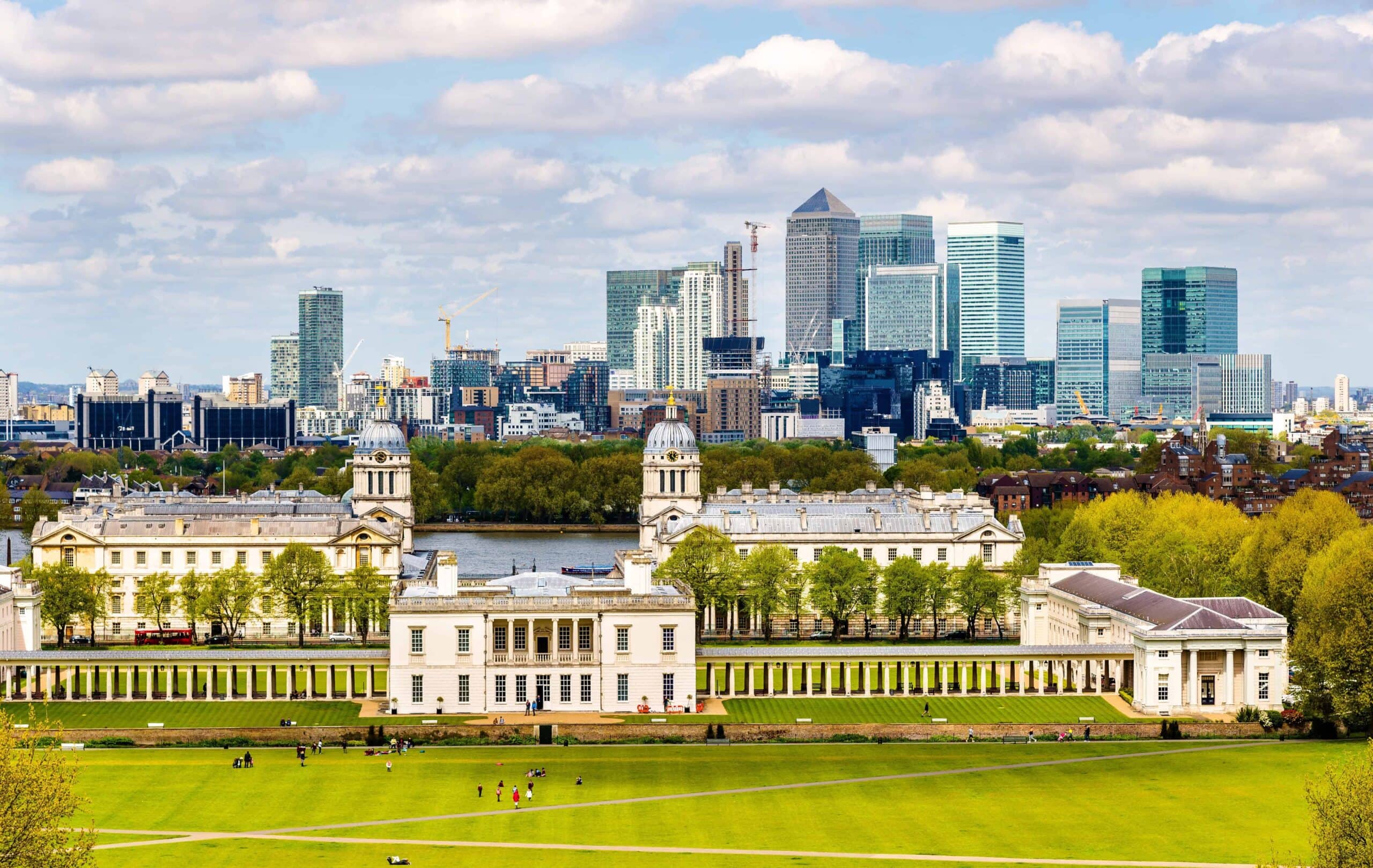 Enjoy a scenic view of Greenwich Park with the Old Royal Naval College in the foreground and London’s Canary Wharf skyscrapers beyond, near some of the best London museums that are free to visit.